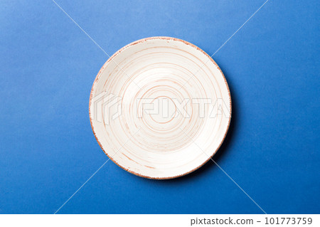 Top view of isolated of colored background empty round beige plate for food. Empty dish with space for your design 101773759