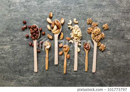 mixed nuts in white wooden spoon. Mix of various nuts on colored background. pistachios, cashews, walnuts, hazelnuts, peanuts and brazil nuts mixed nuts in white wooden spoon. Mix of various nuts on colored background. pistachios, cashews, walnuts, hazelnuts, peanuts and brazil nuts 101773797