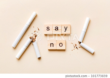 Cigarette And Wooden Blocks, Broken cigarette on table background, No Tobacco Day with hourglass, clock health concept. time to quit smoking Cigarette And Wooden Blocks, Broken cigarette on table background, No Tobacco Day with hourglass, clock health concept. time to quit smoking 101773839