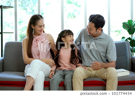 Happy Asian family, father, mother, and daughter living together in the living room. Parent spending a time with their lovely daughter in the free time in weekend together. Happy Asian family, father, mother, and daughter living together in the living room. Parent spending a time with their lovely daughter in the free time in weekend together. 101774434