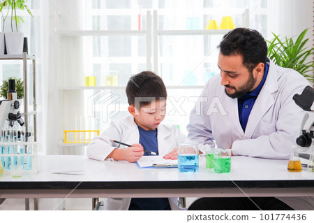 Lovely Asian young boy in lab coat enjoy doing an experiment and studying a science. Smart Asian little boy learning a science experimental with expertise scientist or science researcher in laboratory Lovely Asian young boy in lab coat enjoy doing an experiment and studying a science. Smart Asian little boy learning a science experimental with expertise scientist or science researcher in laboratory 101774436