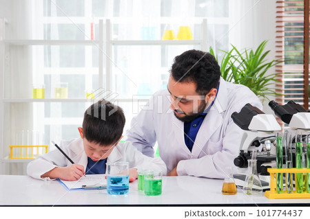 Lovely Asian young boy in lab coat enjoy doing an experiment and studying a science. Smart Asian little boy learning a science experimental with expertise scientist or science researcher in laboratory 101774437