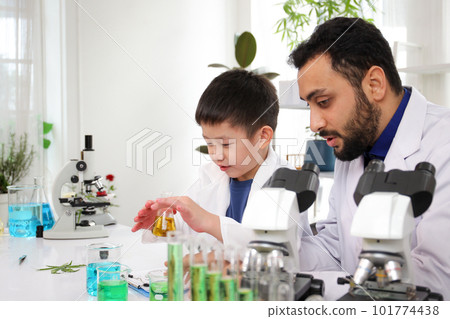 Lovely Asian young boy in lab coat enjoy doing an experiment and studying a science. Smart Asian little boy learning a science experimental with expertise scientist or science researcher in laboratory Lovely Asian young boy in lab coat enjoy doing an experiment and studying a science. Smart Asian little boy learning a science experimental with expertise scientist or science researcher in laboratory 101774438