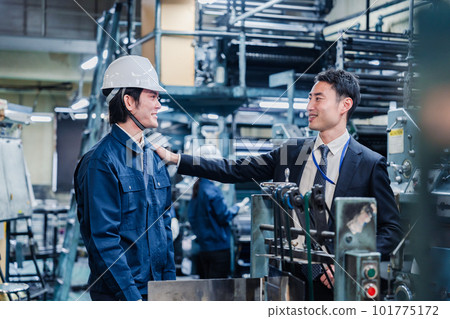 Owner tapping a field staff member on the shoulder 101775172