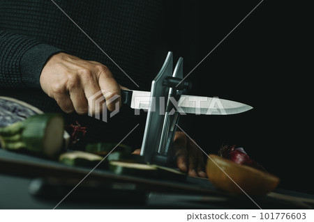 man sharpening a kitchen knife 101776603