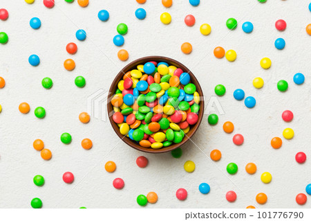 Multicolored candies in a bowl on a colored background. birthday and holiday concept. Top view with copy space 101776790