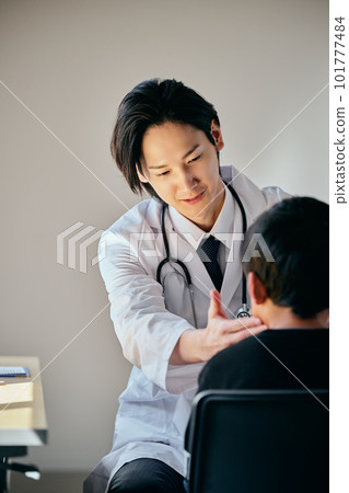 一位年輕的男醫生正在檢查一個小學生 一位年輕的男醫生正在檢查一個小學生 101777484