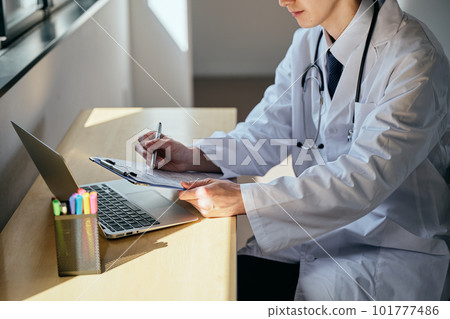 一個穿白大褂的年輕人接受治療 一個穿白大褂的年輕人接受治療 101777486