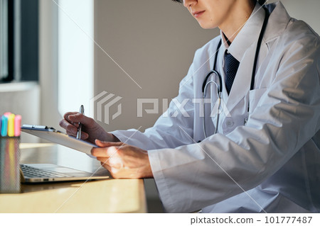 A young man in a white coat giving medical treatment A young man in a white coat giving medical treatment 101777487