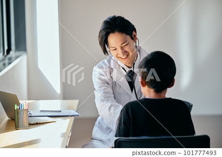 Young male doctor examining with a stethoscope on his stomach Young male doctor examining with a stethoscope on his stomach 101777493