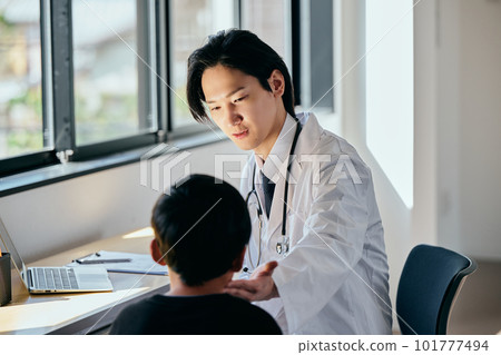 一位年輕的男醫生正在檢查一個小學生 一位年輕的男醫生正在檢查一個小學生 101777494