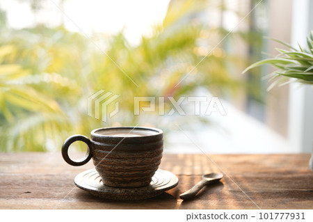 Palm cup and spoon with plant on blue wooden table Palm cup and spoon with plant on blue wooden table 101777931