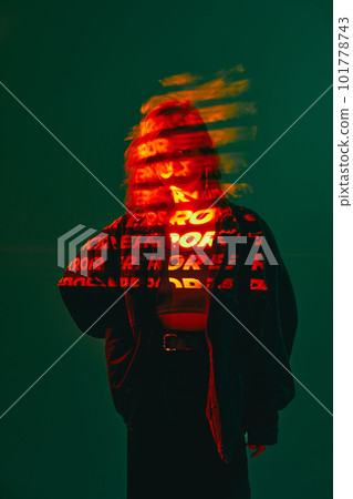 Portrait of pretty girl wearing sunglasses and digital neon filter lights with inscryption on body on dark green mode background. Error, mistake 101778743