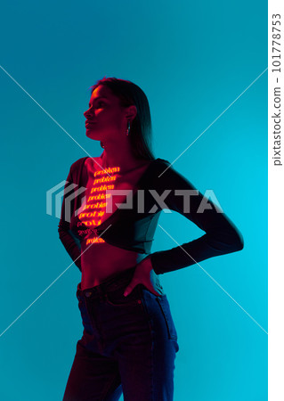 One attractive woman wearing trendy clothes with neon filter lights with inscryption on body on bright green mode background. Problem One attractive woman wearing trendy clothes with neon filter lights with inscryption on body on bright green mode background. Problem 101778753