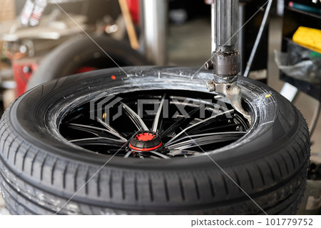 Wheel with tire on tire changing machine in auto repair service. Wheel with tire on tire changing machine in auto repair service. 101779752