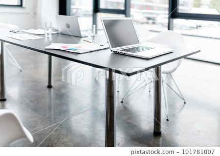 Modern office with graph sheets and laptop on a desk 101781007