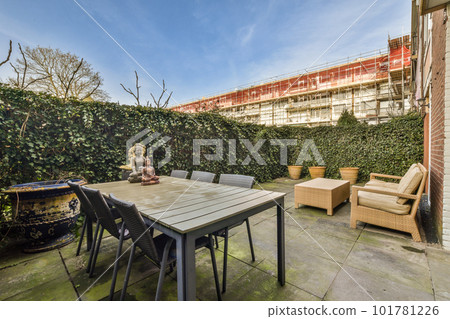 an outside area with furniture and plants on the side of the building, including a table and chairs for two people an outside area with furniture and plants on the side of the building, including a table and chairs for two people 101781226