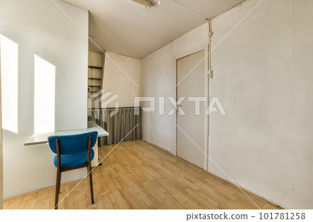 an empty room with a blue chair in the middle and a white wall on the other side, behind it an empty room with a blue chair in the middle and a white wall on the other side, behind it 101781258