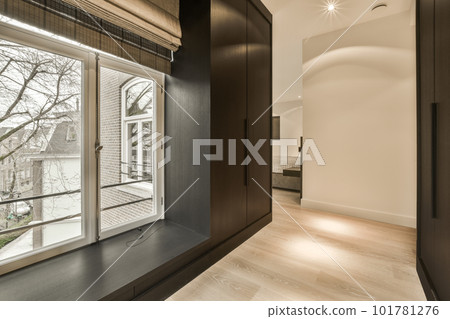 a room with wood flooring and large windows that look out onto the street in front of the apartment building a room with wood flooring and large windows that look out onto the street in front of the apartment building 101781276