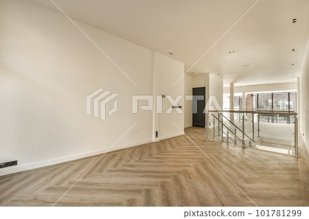an empty living room with wood flooring and white walls on either side of the room there is a staircase leading up to the 101781299