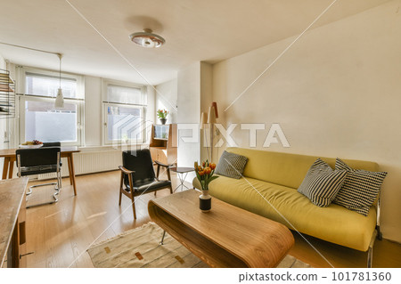 a living room with a couch, coffee table and television set in the corner on the wall is painted white a living room with a couch, coffee table and television set in the corner on the wall is painted white 101781360