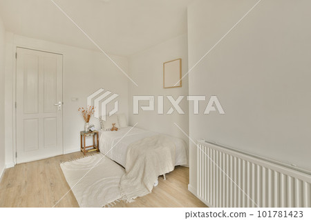 a bedroom with white walls and wood flooring in the room, there is a small bed on the right side a bedroom with white walls and wood flooring in the room, there is a small bed on the right side 101781423