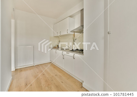 a kitchen area with white cabinets and wood flooring in an apartment or residential building, taken from the inside a kitchen area with white cabinets and wood flooring in an apartment or residential building, taken from the inside 101781445