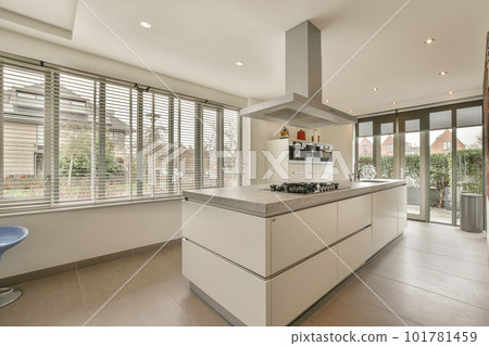 a modern kitchen with white cabinets and marble counter tops in front of the window looking out onto an outside patio a modern kitchen with white cabinets and marble counter tops in front of the window looking out onto an outside patio 101781459
