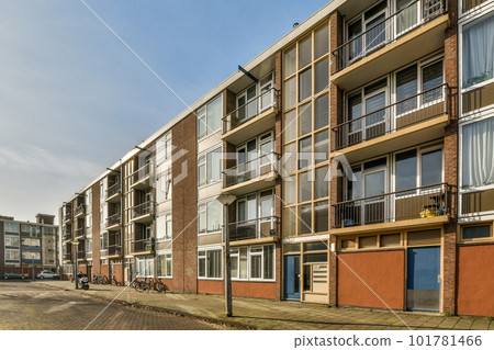 an apartment building with many windows and bales on the side of the street in front of the building is clear blue sky an apartment building with many windows and bales on the side of the street in front of the building is clear blue sky 101781466