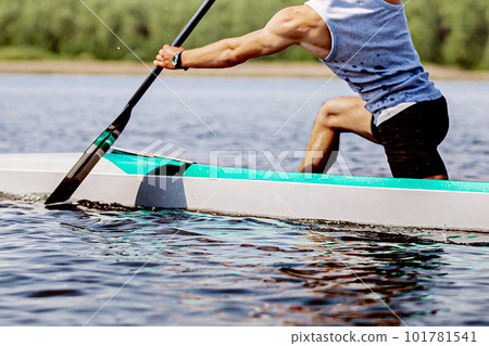 close-up part body male canoeist on canoe single rowing training on lake, muscular arm to hold paddle close-up part body male canoeist on canoe single rowing training on lake, muscular arm to hold paddle 101781541