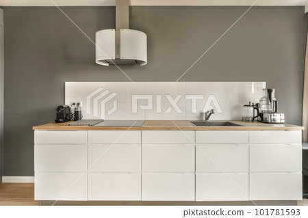 a kitchen with white cabinets and wood counter tops on the island in front of the sink is also gray walls a kitchen with white cabinets and wood counter tops on the island in front of the sink is also gray walls 101781593