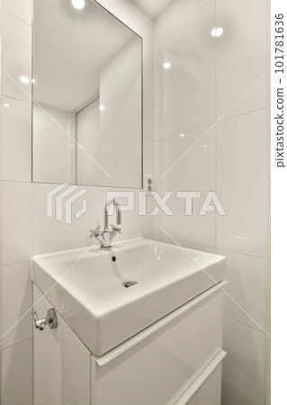 a white bathroom with a mirror above the sink and light fixtures on the wall in the room is very clean a white bathroom with a mirror above the sink and light fixtures on the wall in the room is very clean 101781636