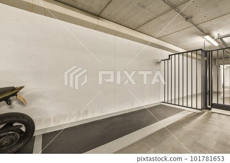 a motorcycle parked in front of a white wall with black metal bars on the sides and an open door behind it 101781653