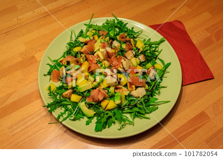 Fresh healthy salad with mango, avocado, salmon, arugula and croutons on wooden table Fresh healthy salad with mango, avocado, salmon, arugula and croutons on wooden table 101782054