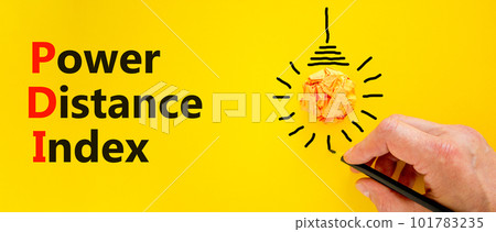 PDI power distance index symbol. Concept words PDI power distance index on yellow paper on a beautiful yellow background. Businessman hand. Business PDI power distance index concept. Copy space. 101783235