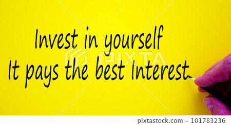 Hand writing 'invest in youpself it pays the best interest', isolated on yellow background. Business concept. 101783236