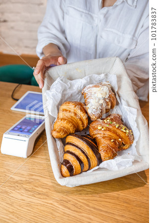 A tempting display of croissants in a wooden basket at the checkout. A tempting display of croissants in a wooden basket at the checkout. 101783837