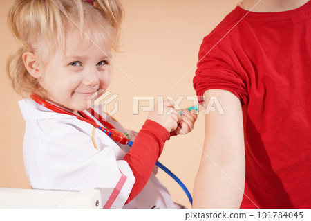 The child plays doctor and injects his older brother. Children are vaccinated. 101784045