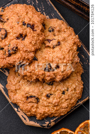Delicious baked oatmeal raisin cookies on a dark concrete background Delicious baked oatmeal raisin cookies on a dark concrete background 101784126