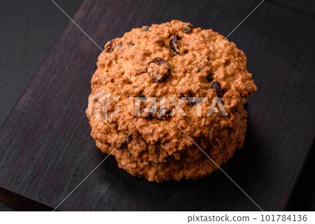 Delicious baked oatmeal raisin cookies on a dark concrete background Delicious baked oatmeal raisin cookies on a dark concrete background 101784136