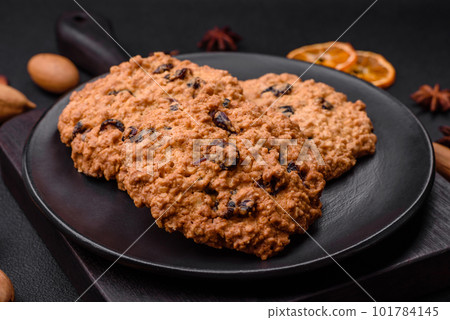 Delicious baked oatmeal raisin cookies on a dark concrete background 101784145
