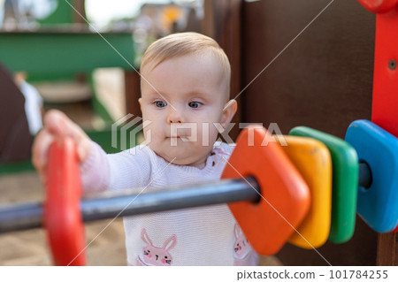 Cute baby Playing on Playground. Toddler playing with colored rings on playground 101784255