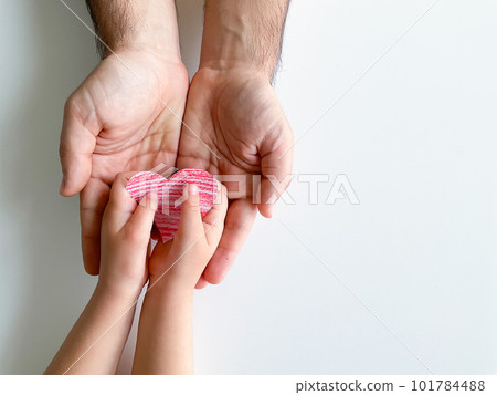 child gives adult small red paper heart. Fathers Day. Family, love, parents 101784488