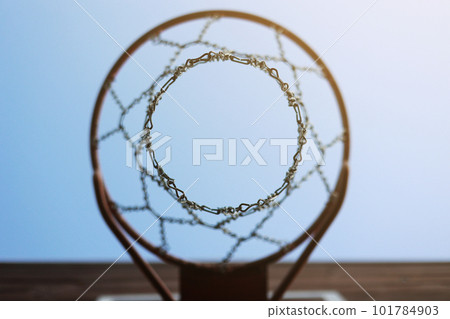 basketball hoop with metal net and wooden backboard on blue sky background. Basketball court outdoors. Recreational sport equipment on streetball field alfresco, playground on street. bottom view 101784903