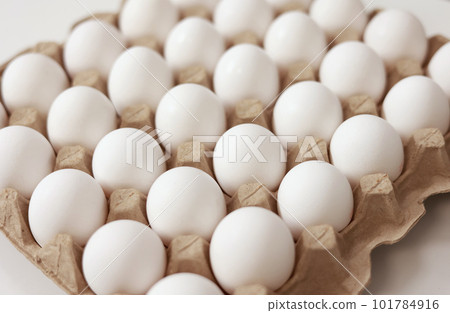 Close Up of raw chicken eggs in paper egg tray on white background. Group of Fresh white Eggs in a cardboard cassette. Organic food from nature good for health. 101784916