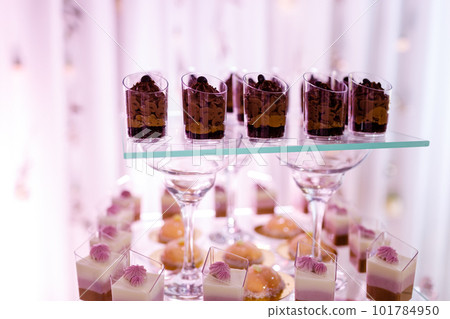 Candy bar on wedding ceremony with a lot of different modern desserts, cupcakes, sweets with fruits. Delicious candy bar. Catering Concept. selective focus Candy bar on wedding ceremony with a lot of different modern desserts, cupcakes, sweets with fruits. Delicious candy bar. Catering Concept. selective focus 101784950