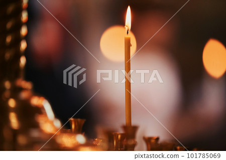 Burning candles on bronze candlestick against dark background at home.candles in the interior. Vintage style. Calm romantic atmosphere. Horizontal image for design. Burning candles on bronze candlestick against dark background at home.candles in the interior. Vintage style. Calm romantic atmosphere. Horizontal image for design. 101785069