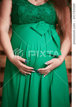 pregnant woman in a beautiful dress. Focus on the abdomen. pregnant woman in a beautiful dress. Focus on the abdomen. 101785089