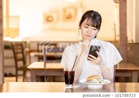 亞洲女性正在用智能手機查看前來吃午餐的咖啡館和餐館的評論和 SNS 亞洲女性正在用智能手機查看前來吃午餐的咖啡館和餐館的評論和 SNS 101786723