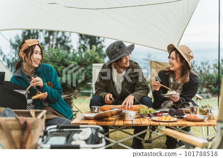 Asian couple camper and friend woman cooking at campsite in autumn winter Asian couple camper and friend woman cooking at campsite in autumn winter 101788518